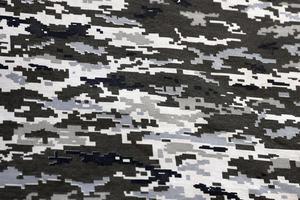 Fabric with texture of Ukrainian military pixeled camouflage. Cloth with camo pattern in grey, brown and green pixel shapes. Official uniform of Ukrainian soldiers photo