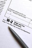 The pen lies on the tax form W-2 Wage and Tax Statement. The time to pay taxes photo