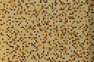 The texture of the wall, decorated with a mosaic of various small square tiles. Abstract pattern of ceramic tiles on the wall photo
