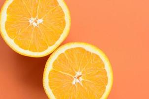 Top view of a several orange fruit slices on bright background in orange color. A saturated citrus texture image photo