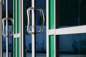 Chrome door handle and glass of modern aluminium office facade photo