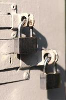 A photograph of the fragment is a metal door with two square padlocks. Selective focus with shallow depth of field photo