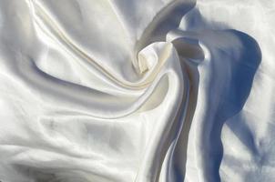 Smooth elegant white silk or satin luxury cloth texture can use as wedding background. Luxurious background design photo