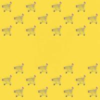 Shopping addiction, shopping lover or shopaholic concept. Many small empty shopping carts perform a pattern on a pastel colored paper background. Flat lay composition, top view photo