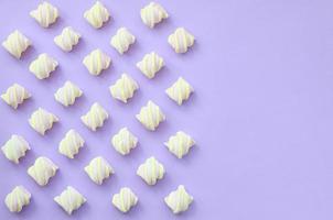 Colorful marshmallow laid out on violet paper background. pastel creative textures with copy space. minimal photo