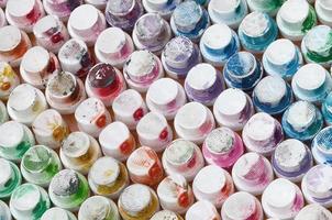 A pattern from a many nozzles from a paint sprayer for drawing graffiti, smeared into different colors. The plastic caps are arranged in many rows forming the color of the rainbow photo