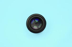 Camera lens with a closed aperture lie on texture background of fashion pastel blue color paper photo