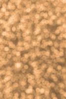 Blurred orange decorative sequins. Background image with shiny bokeh lights from small elements photo