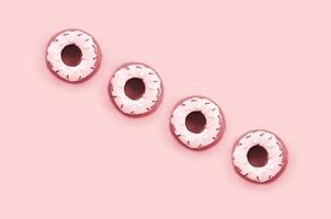 Many small plastic donuts lies on a pastel colorful background. Flat lay minimal pattern. Top view photo