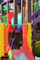 Fragment of a playground made of plastic and wood, painted in different colors photo