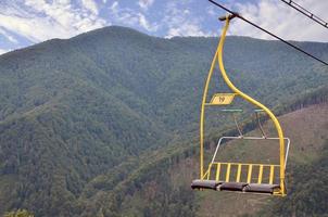 The seats of the cable car on the background of Mount Makovitsa, one of the Carpathian Mountains photo