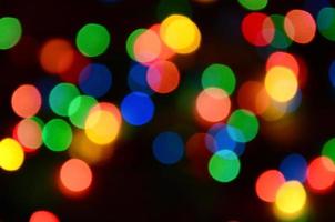 Blurred festive colorful lights over black useful as background. All main colors included. Red, yellow, green and blue photo