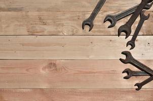 unas cuantas llaves oxidadas se encuentran sobre una mesa de madera en un taller