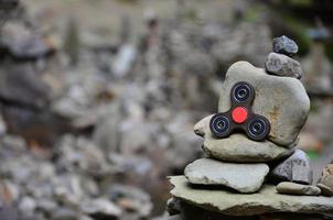 A wooden spinner lies on strange stone structures in the forest photo