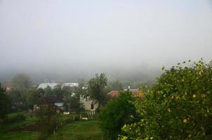 The apartment building is in front of a thick layer of fog. Living in a mountainous area in the Carpathians, Ukraine photo