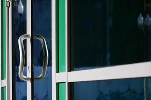 Chrome door handle and glass of modern aluminium office facade photo