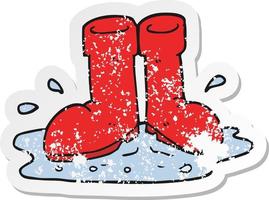 retro distressed sticker of a cartoon wellington boots in puddle vector