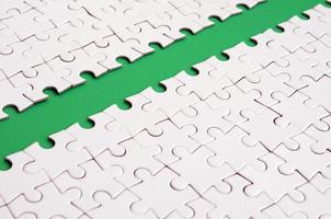 The green path is laid on the platform of a white folded jigsaw puzzle. Texture image with copy space for text photo