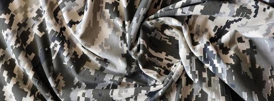 Fabric with texture of Ukrainian military pixeled camouflage. Cloth with camo pattern in grey, brown and green pixel shapes. Official uniform of Ukrainian soldiers photo