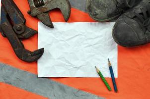 Adjustable wrenches with old boots and a sheet of paper with two photo