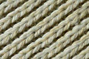 Fabric texture of a soft yellow knitted sweater. Macro image of the structure of bindings in yarns photo