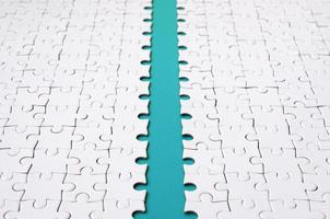 The blue path is laid on the platform of a white folded jigsaw puzzle. Texture image with copy space for text photo