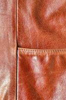 Brown leather texture. Useful as background for any design work. Macro photography of outerwear made of genuine leather photo