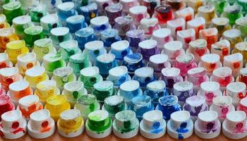 A pattern from a many nozzles from a paint sprayer for drawing graffiti, smeared into different colors. The plastic caps are arranged in many rows forming the color of the rainbow photo