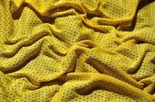 Yellow sport clothing fabric texture background. Top view of yellow cloth textile surface. Bright basketball shirt. Text space photo