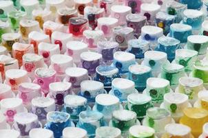 A pattern from a many nozzles from a paint sprayer for drawing graffiti, smeared into different colors. The plastic caps are arranged in many rows forming the color of the rainbow photo