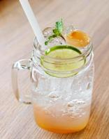 glass of ice lemonade on wooden table photo