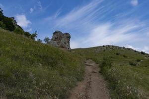 Mountain landscape, stone pillars in the form of ghosts, stone idols in a mountain valley, a canyon against the sky. photo