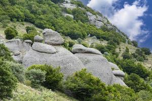 Mountain landscape, stone pillars in the form of ghosts, stone idols in a mountain valley, a canyon against the sky. photo