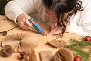 la niña hace decoraciones para árboles de navidad con papel con sus propias manos. paso 3. instrucción paso a paso foto