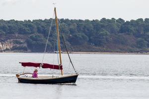 Arne, Dorset, UK - September 20. View of a yacht passing Arne in Dorset on September 20, 2022. One unidentified person photo