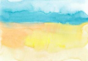 textura de fondo azul, amarillo y naranja acuarela, pintada a mano. telón de fondo artístico, manchas en papel. fondo de pantalla de pintura de acuarela. foto