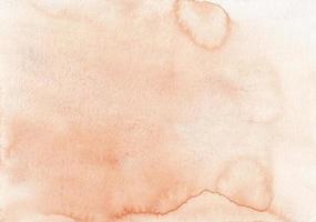 textura de fondo de color melocotón pastel acuarela. manchas de color naranja claro sobre papel, pintado a mano. foto