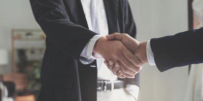 Two confident business man shaking hands during a meeting in the office, success, dealing, greeting and partner concept. photo