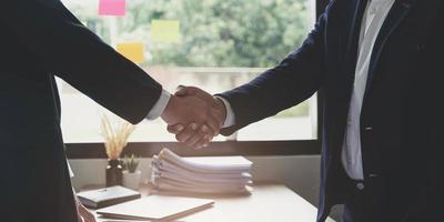 dos hombres de negocios confiados dándose la mano durante una reunión en la oficina, el éxito, el trato, el saludo y el concepto de socio. foto