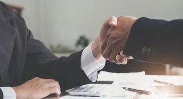 Two confident business man shaking hands during a meeting in the office, success, dealing, greeting and partner concept. photo