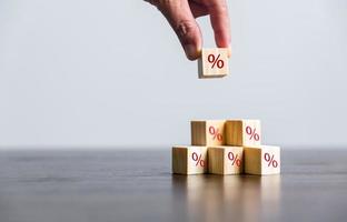 Closeup wood cubes with percentage symbol, Interest rate and dividend concept, wooden block with percentage symbol and up arrow, return on stocks and mutual funds, long term investment for retirement. photo