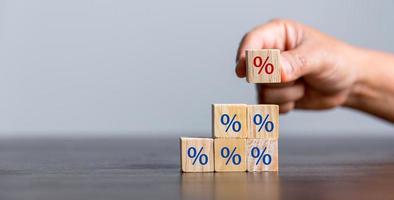 Closeup wood cubes with percentage symbol, Interest rate and dividend concept, wooden block with percentage symbol and up arrow, return on stocks and mutual funds, long term investment for retirement. photo