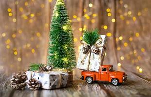 coche en miniatura sobre fondo de madera con luz de navidad foto