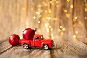 coche en miniatura sobre fondo de madera con luz de navidad. foto