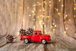 coche en miniatura sobre fondo de madera con luz de navidad. foto