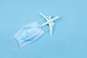 Airplane in flight with a medical mask. Concept - observance of safety on the plane. Traveling by air at social distance. Compliance with the recommendations of doctors on trips. Opening borders. photo
