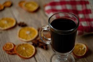 rodajas de naranja secas y vino caliente en la mesa foto