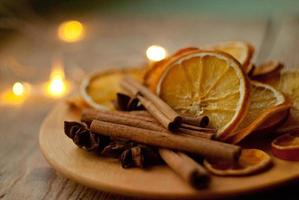 rodajas de naranja secas y vino caliente en la mesa foto