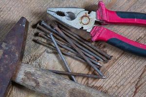 Different tools on a wooden background. Nails, hammer, pliers photo