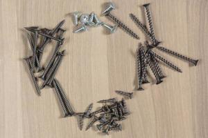 Different tools on a wooden background. Self-tapping screws photo